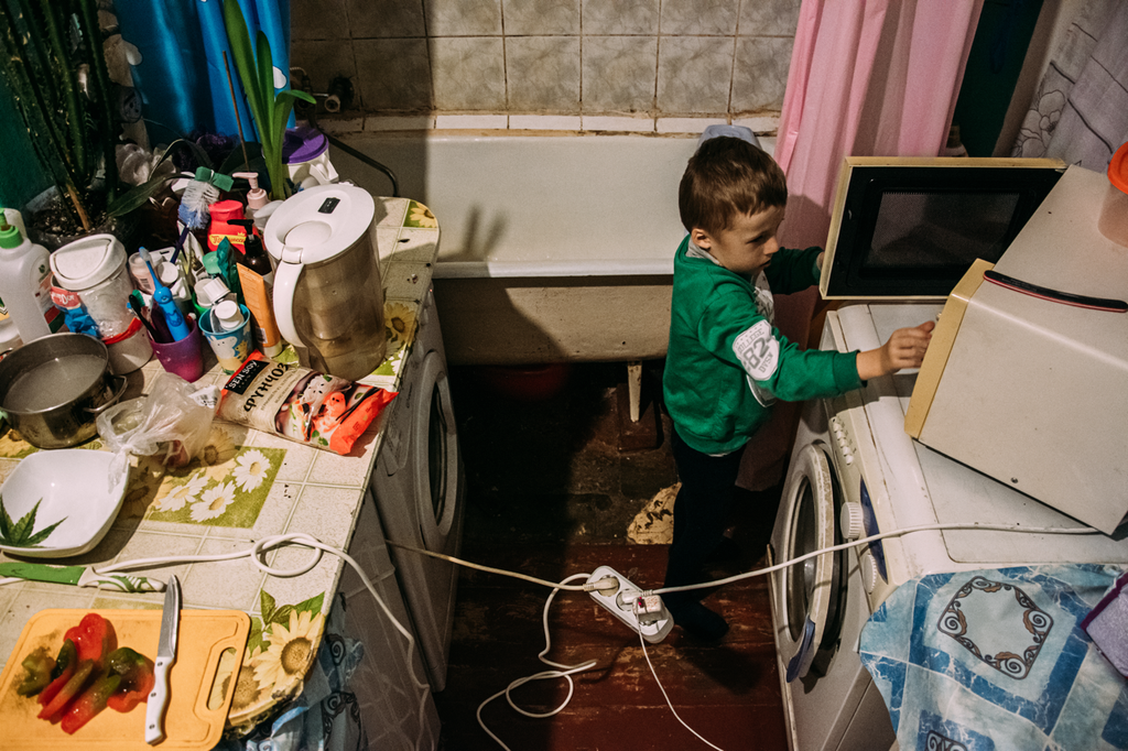 «Счастливая безысходность». Фоторепортаж о жизни многодетной семьи в петербургской коммуналке, Ванная и кухня находятся в одном месте — все электроприборы соединяет один удлинитель — discours.io