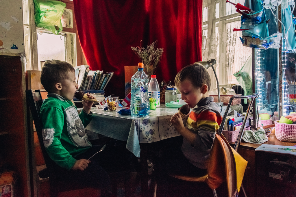 «Счастливая безысходность». Фоторепортаж о жизни многодетной семьи в петербургской коммуналке, Полдник. Мальчики едят мороженое — discours.io