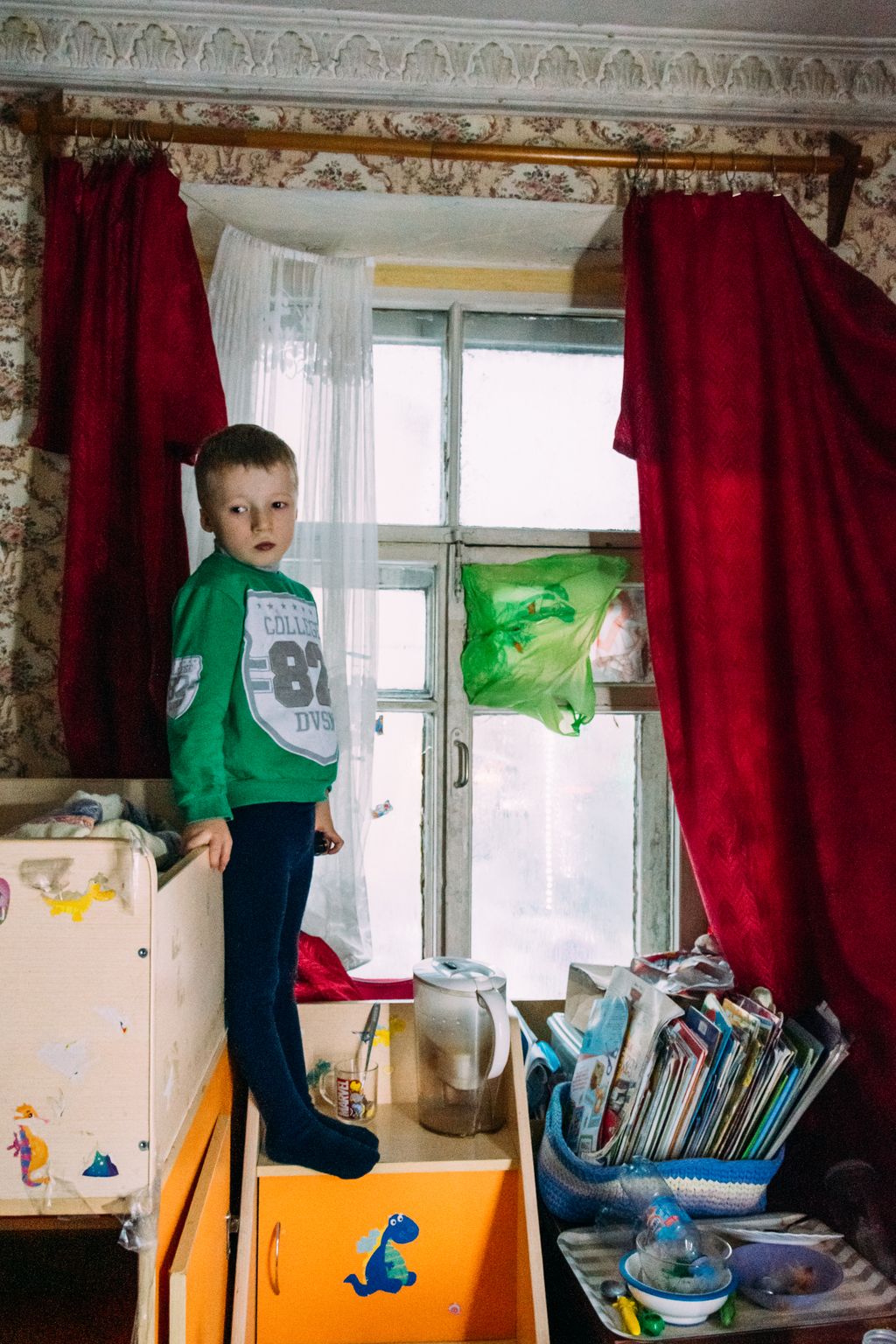 «Счастливая безысходность». Фоторепортаж о жизни многодетной семьи в петербургской коммуналке, Макар у своей кровати — discours.io