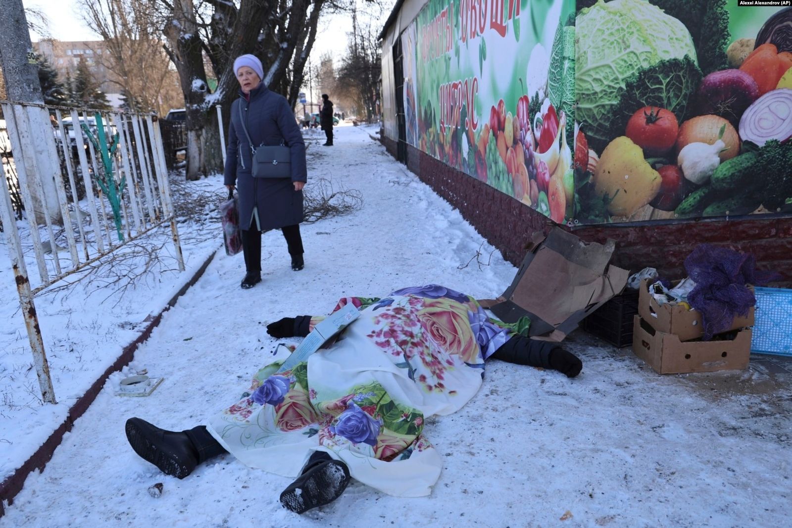 Женщина проходит мимо тела погибшего жителя Донецка, убитого в результате украинского обстрела по городу. В результате атаки погибли по меньшей мере 27 человек. 21 января / Alexei Alexandrov / AP