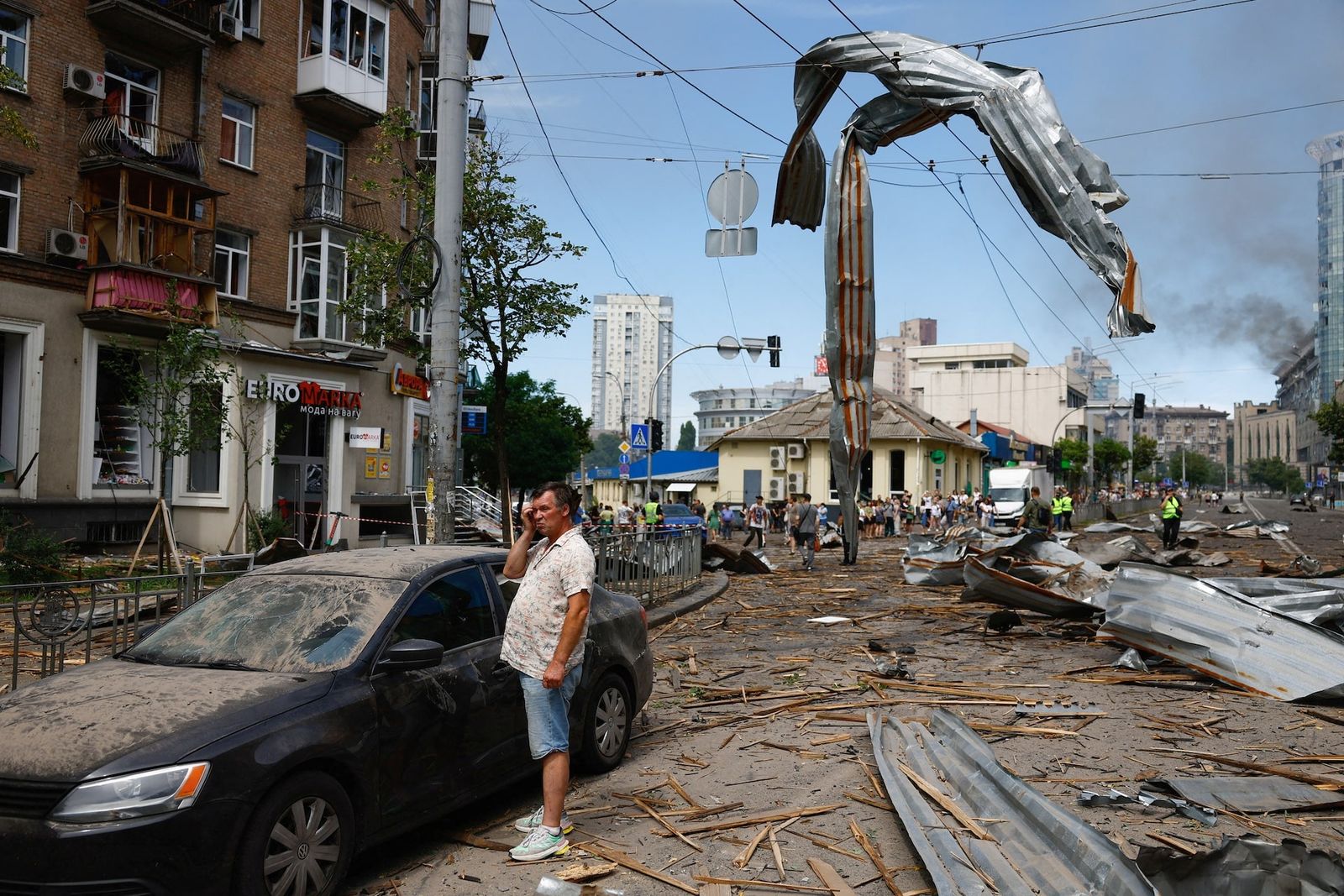 Местный житель в Киеве стоит рядом со своим автомобилем, поврежденным после массированного ракетного удара, в результате которого по всей стране погибли более 40 человек. 8 июля /Valentyn Ogirenko / REUTERS