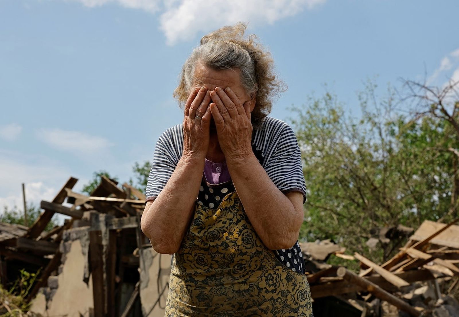 90-летняя жительница села Розовка Валентина Чернова у своего разрушенного дома после недавнего обстрела в самопровозглашенной ДНР. 3 июня / Alexander Ermochenko / REUTERS