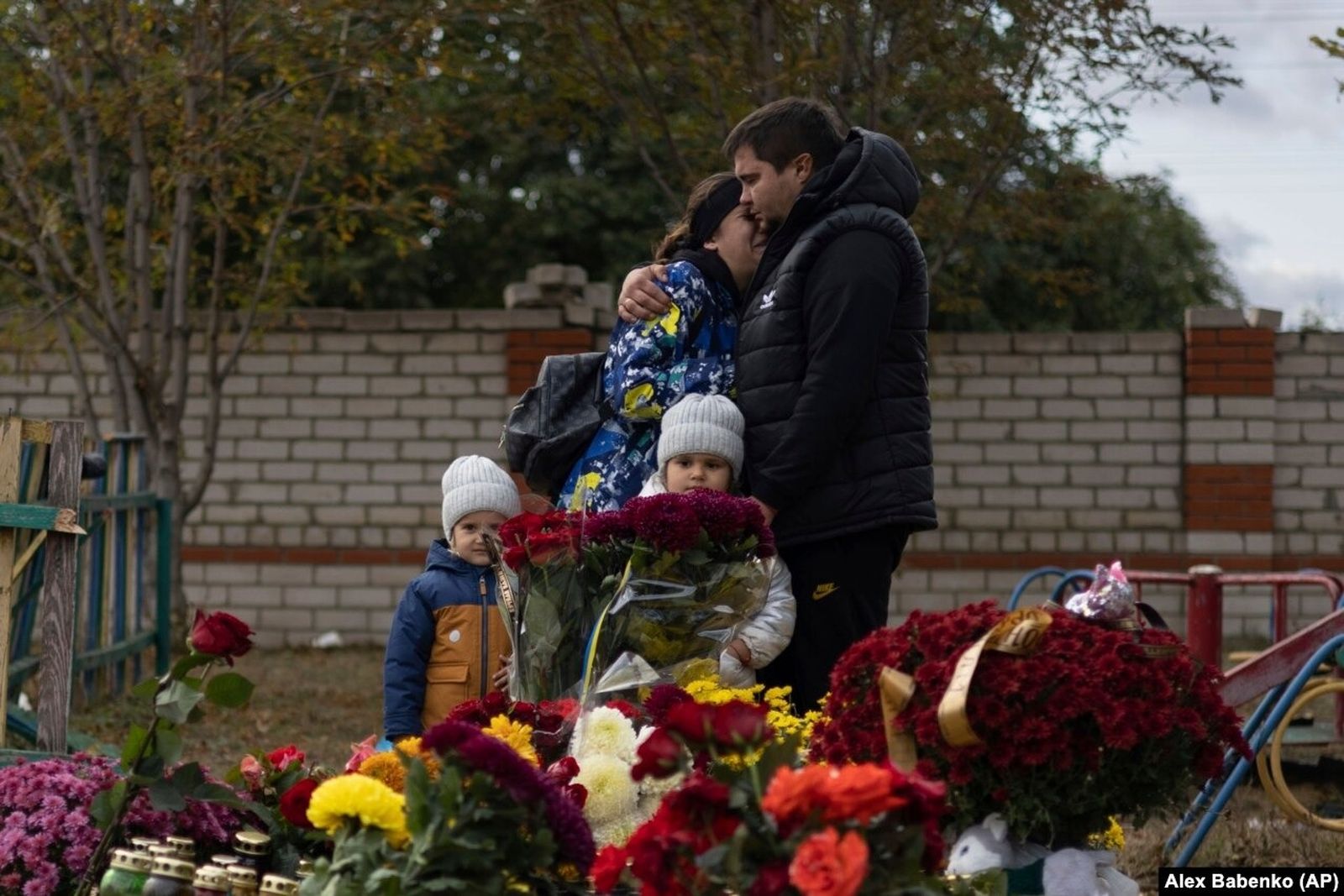 Местные жители плачут возле мемориала жертвам смертоносного российского ракетного обстрела в украинском селе Гроза под Харьковом, где погибли 59 человек. 9 октября / Alex Babenko / AP / Radio Liberty 