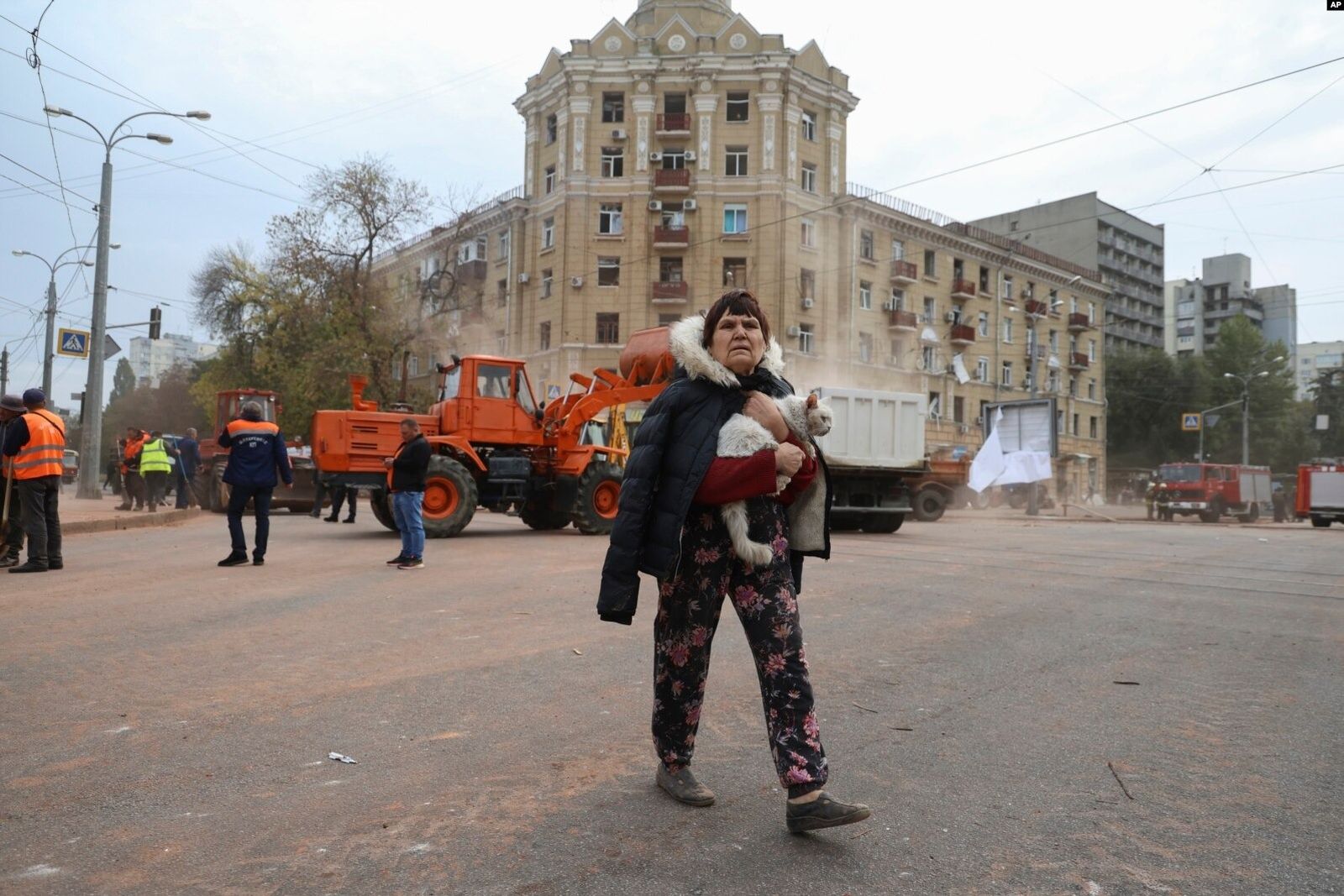 Местная жительница несет кошку, проходя мимо жилого дома, поврежденного в результате обстрела российской ракеты в центре Харькова. 6 октября / Alex Babenko / AP Photo