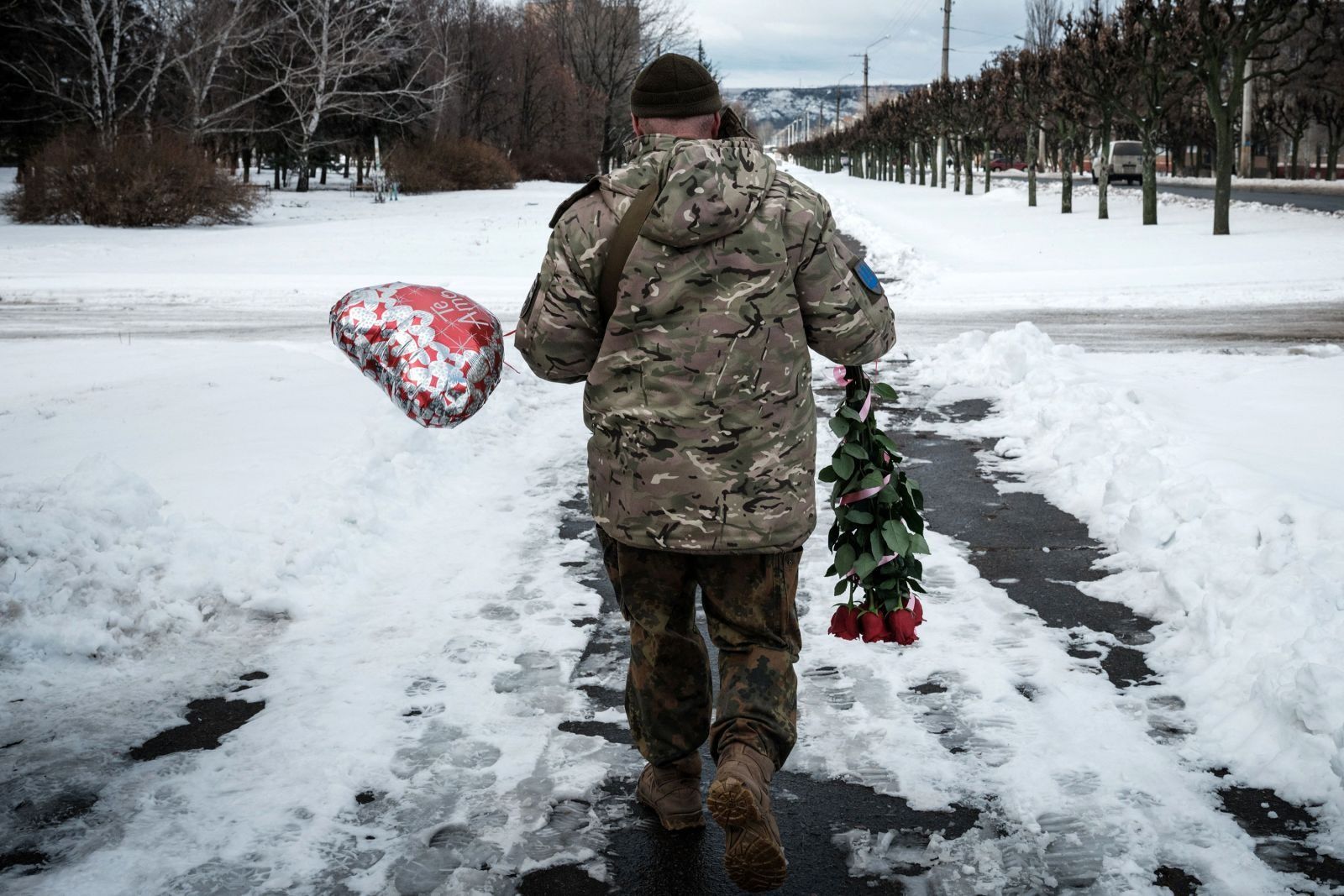 Украинский военный в Краматорске  гуляет с цветами и воздушным шаром, которые он купил на День святого Валентина. 14 февраля / Yasuyoshi Chiba/AFP/Getty Images / CNN