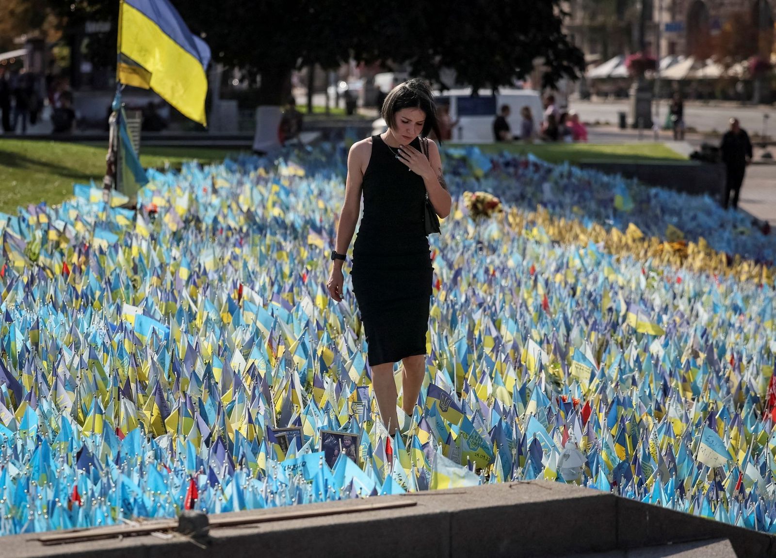 Женщина посещает импровизированный мемориал с украинскими флагами и именами погибших военнослужащих на площади Независимости в Киеве. 27 сентября / Gleb Garanich / Reuters