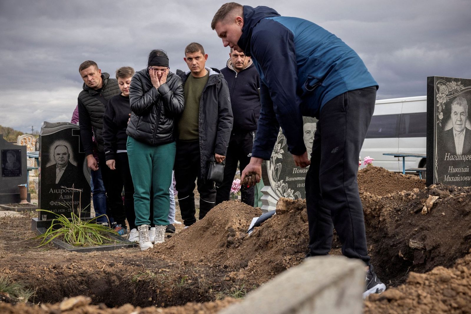 Родственники хоронят 52-летнюю Татьяну Харбаку, погибшую в результате российской ракетной атаки на фоне продолжающегося вторжения России в Украину, на деревенском кладбище в Грозе под Харьковом. 10 октября / Thomas Peter /  Reuters​