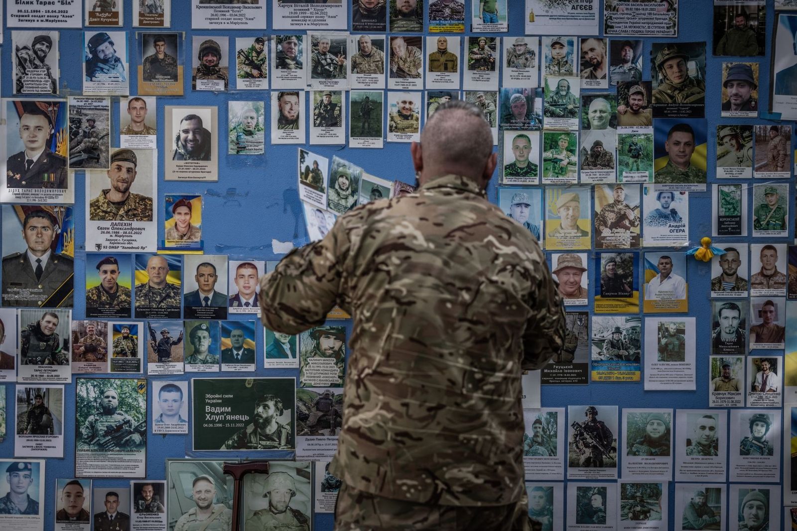 Украинский военный размещает фотографию погибшего на фронте товарища на Стене памяти возле здания МИД Украины в Киеве. 11 сентября / Oliver Weiken / dpa / Scanpix / LETA / Meduza