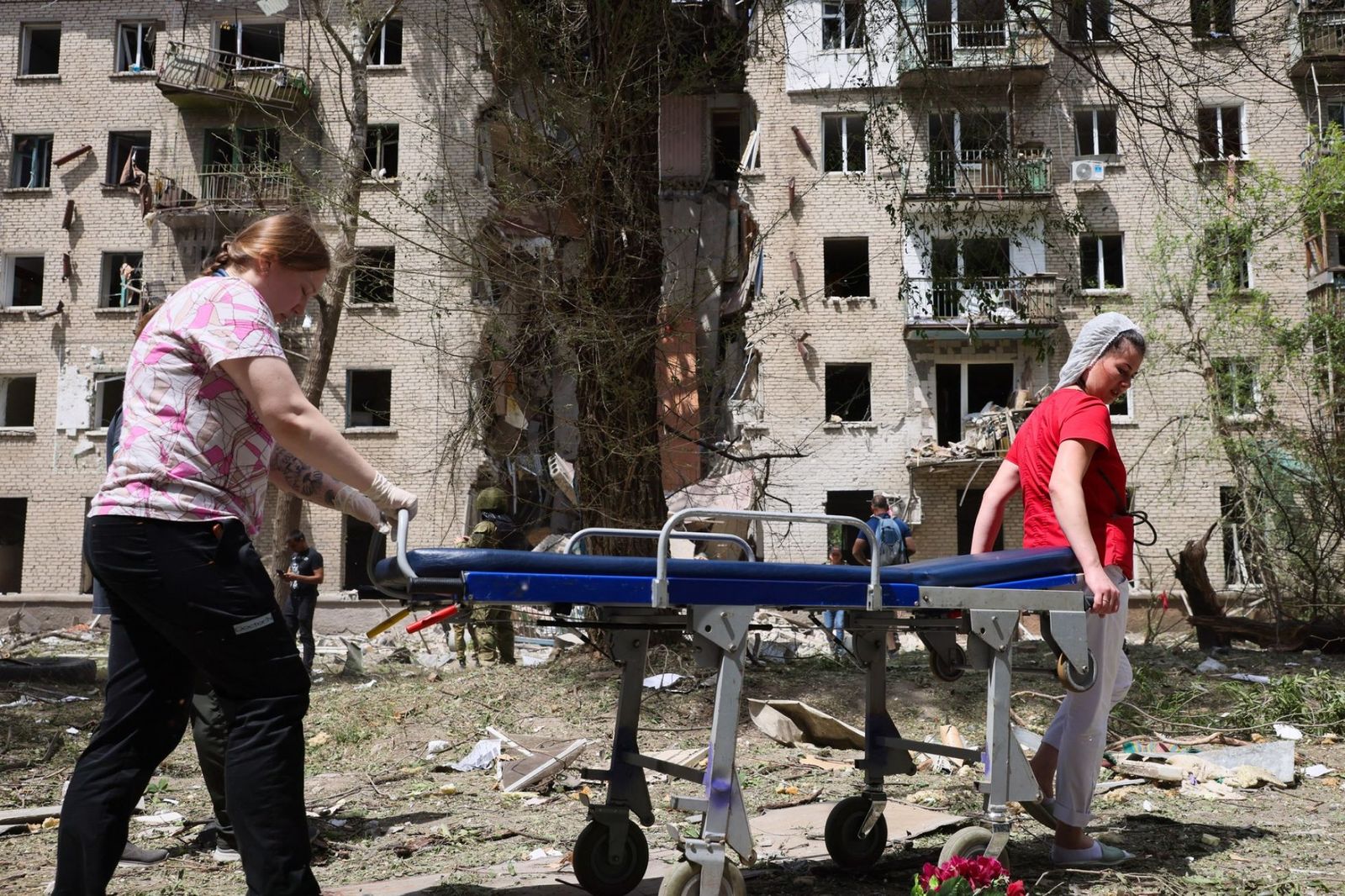 Медицинские работники везут каталку во дворе дома жилого дома в Луганске, разрушенного при украинском ракетном ударе. 7 июня / Александр Река / ТАСС / Profimedia