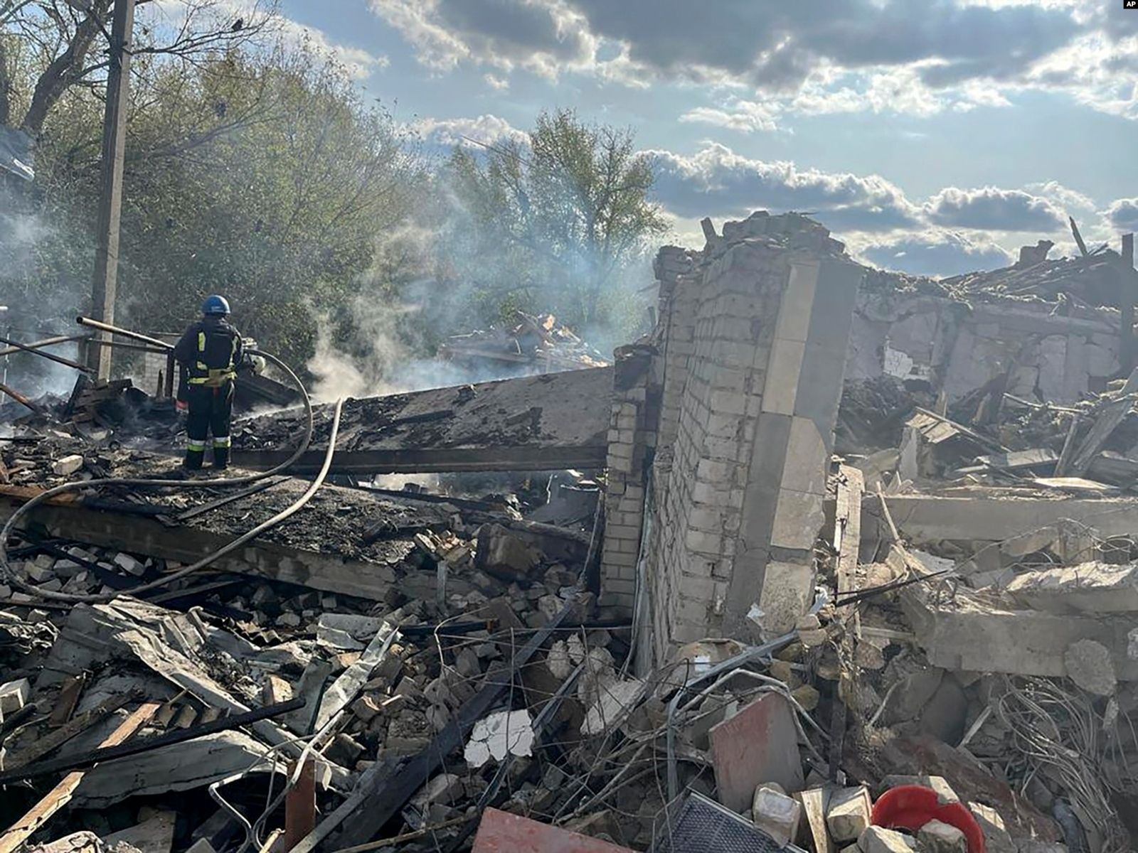 Спасатели тушат пожар после разрушительного российского ракетного обстрела, в результате которого погибли 59 человек в селе Гроза под Харьковом. 5 октября / Ukrainian Presidential Press Office via AP
