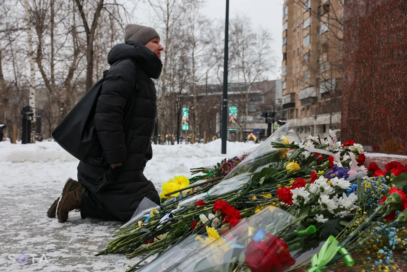 Женщина возлагает цветы в Москве в год войны, чтобы выразить свою скорбь. 24 февраля / Snusmumriken / SOTA  