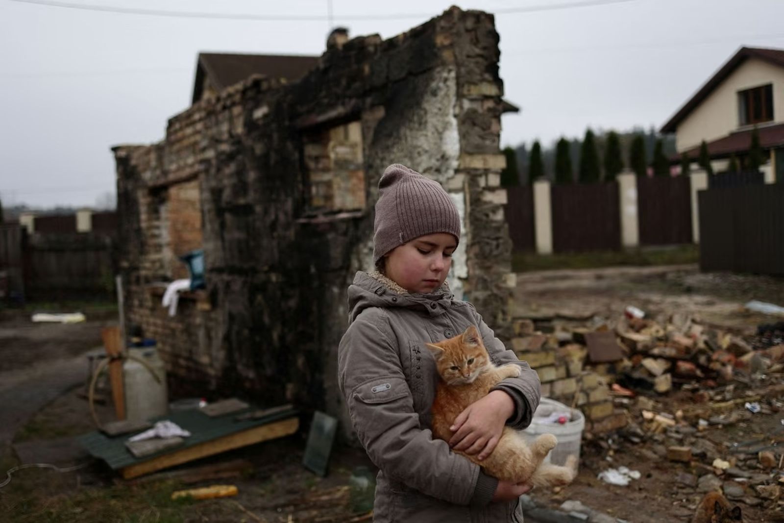 9-летняя Юлия Заика обнимает своего кота Марсика возле разрушенного дома своей сводной сестры Катерины Тищенко в селе Мощунь под Киевом. 8 ноября / Murad Sezer / Reuters / Atlantic