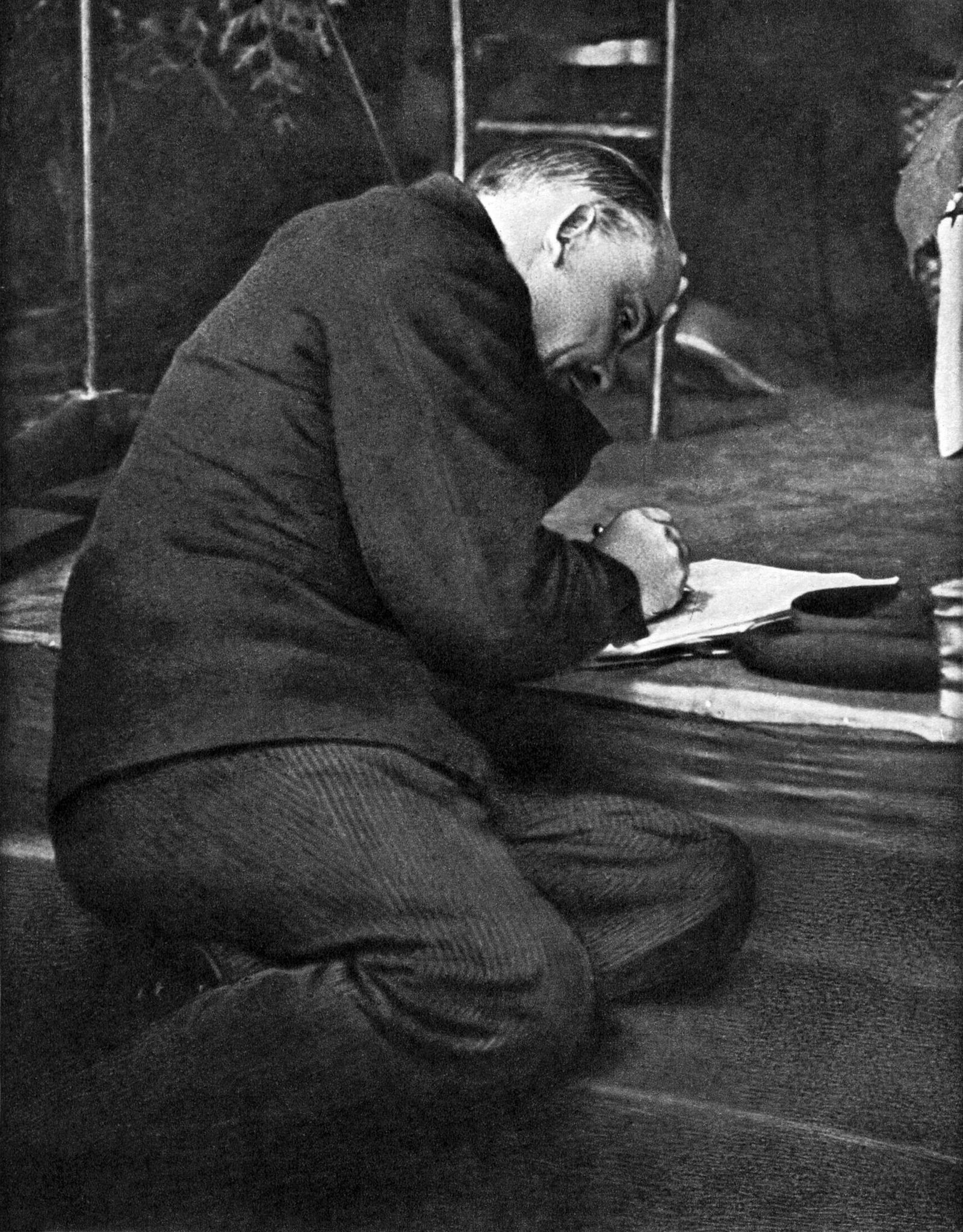 В. И. Ленин на заседании III конгресса Коминтерна, сидя на ступеньках трибуны, делает записи. Москва, июнь–июль 1921 года / Неизвестный автор В. И. Ленин на заседании III конгресса Коминтерна, сидя на ступеньках трибуны, делает записи. Москва, июнь–июль 1921 года / Неизвестный автор