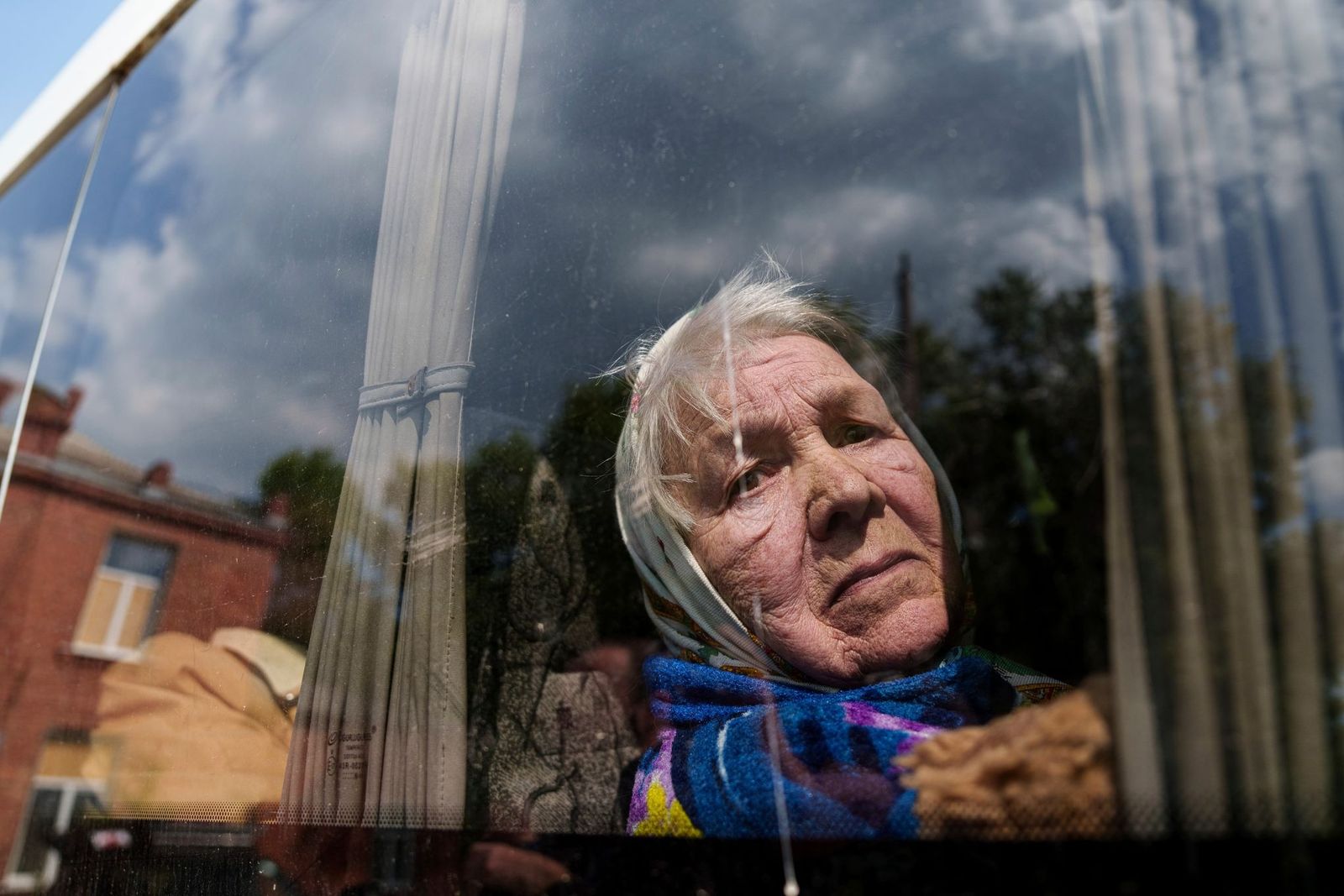 85-летняя Людмила смотрит в окно автобуса после эвакуации из Вовчанска, Украина. Ее муж погиб дома после российского авиаудара. 12 мая /Evgeniy Maloletka  / AP Photo / Фотохроника войны. Главные снимки мая: оборона Орехова, штурм Волчанска и последствия наступления на Харьков — Discours.io
