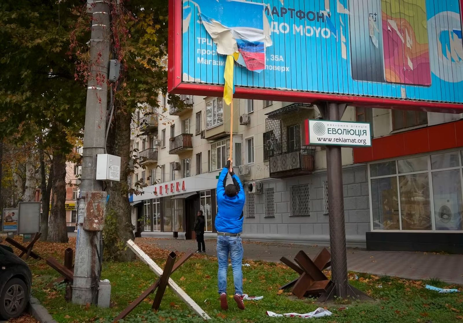 Рабочий снимает российский флаг с билборда в Херсоне. 13 ноября / Efrem Lukatsky / AP / Atlantic