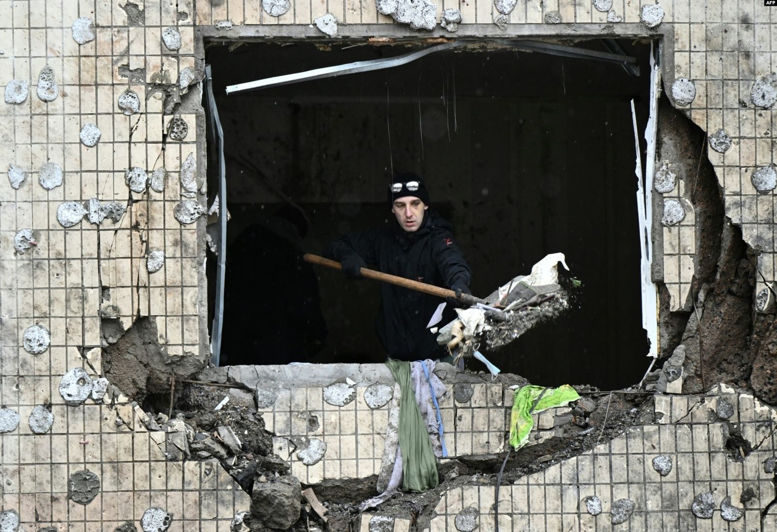 Местный житель разбирает завалы в квартире сильно поврежденного жилого дома через три дня после российского ракетного обстрела в Киеве. 5 января / Genya Savilov / AFP