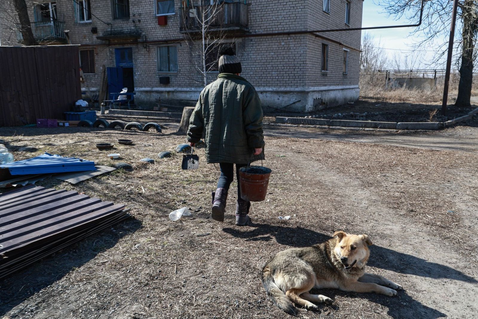  Жительница села Спартак несет уголь для отопления своего дома. Оккупированный Россией поселок расположен между Донецком и Авдеевкой и на протяжении 10 лет боевых действий был одной из точек активных боев на Донецком фронте, в нем проживает 43 челове