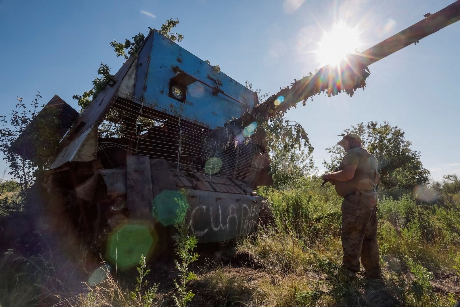 Украинский военнослужащий рядом с советским основным боевым танком Т-62, оснащенным защитой от беспилотников, который был захвачен подразделением в Донецкой области. 19 июня / Alina Smutko / REUTERS