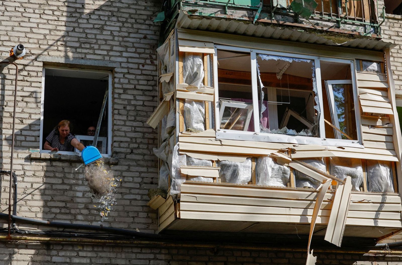 Жительница обстрелянного дома убирает квартиру после атаки. 7 июня / Alexander Ermochenko / Reuters / Scanpix / LETA