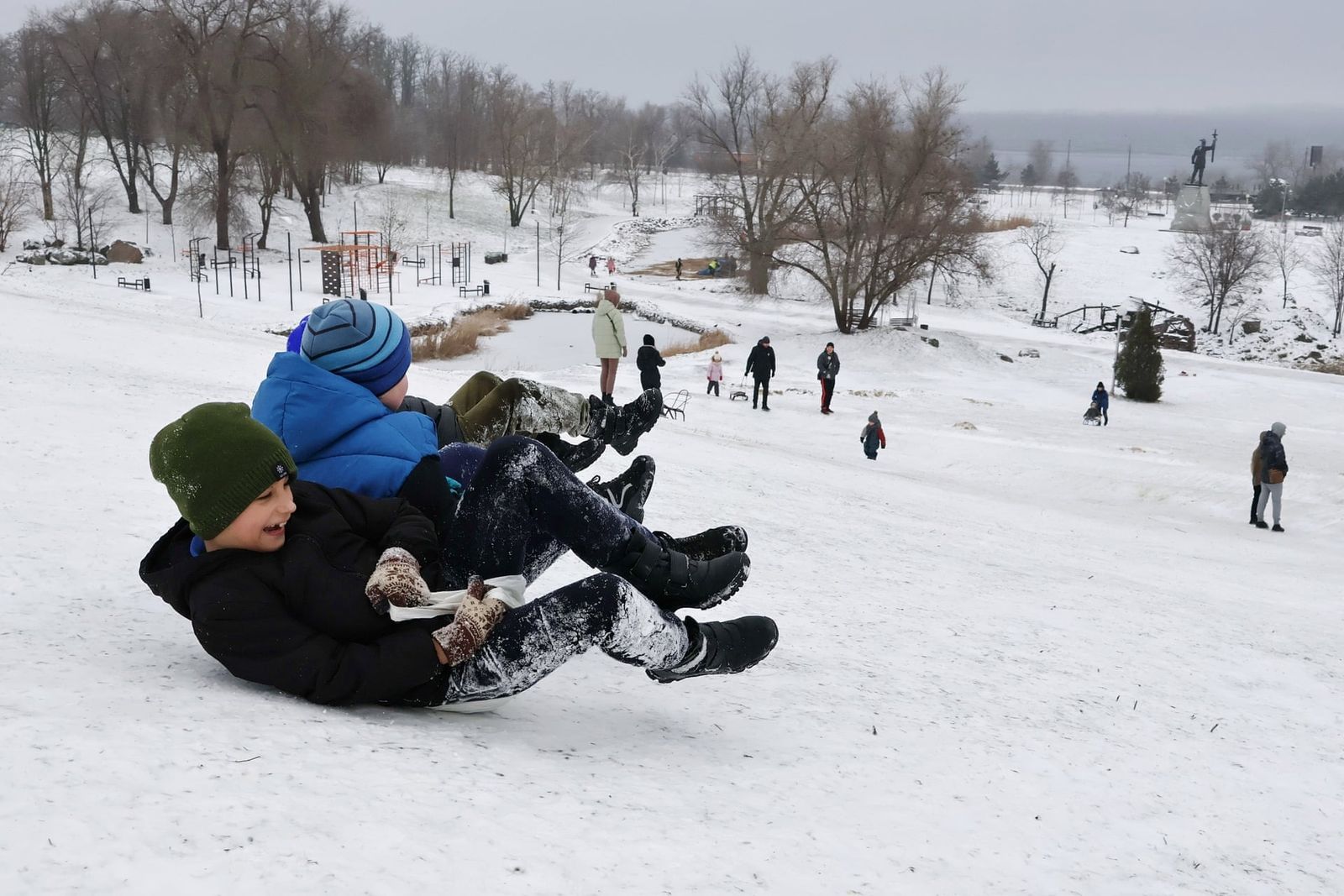 Дети катаются на санках с горки в городском парке в Запорожье. 12 января / Andriy Andriyenko / SOPA