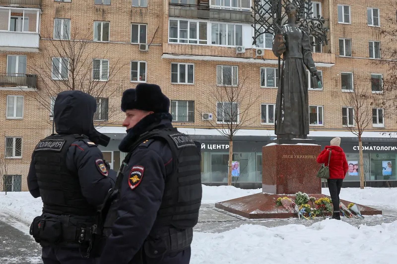 Полицейские наблюдают за тем, как жители Москвы приносят цветы к памятнику Лесе Украинке. 24 февраля / Reuters / The Guardian