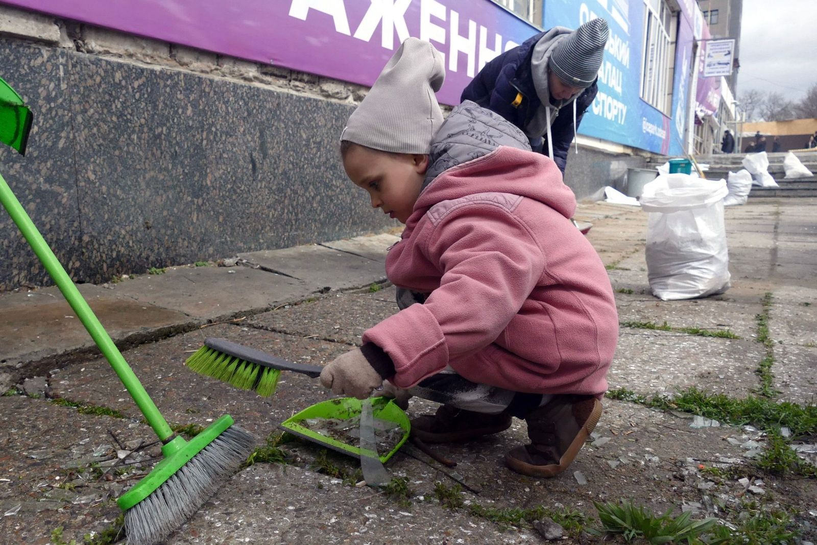 Ребенок собирает в совок осколки стекла, выбитого в результате российского обстрела в Одессе. 29 марта / Yulii Zozulia / Укринформ / ZUMA Press Wire / Scanpix / LETA 