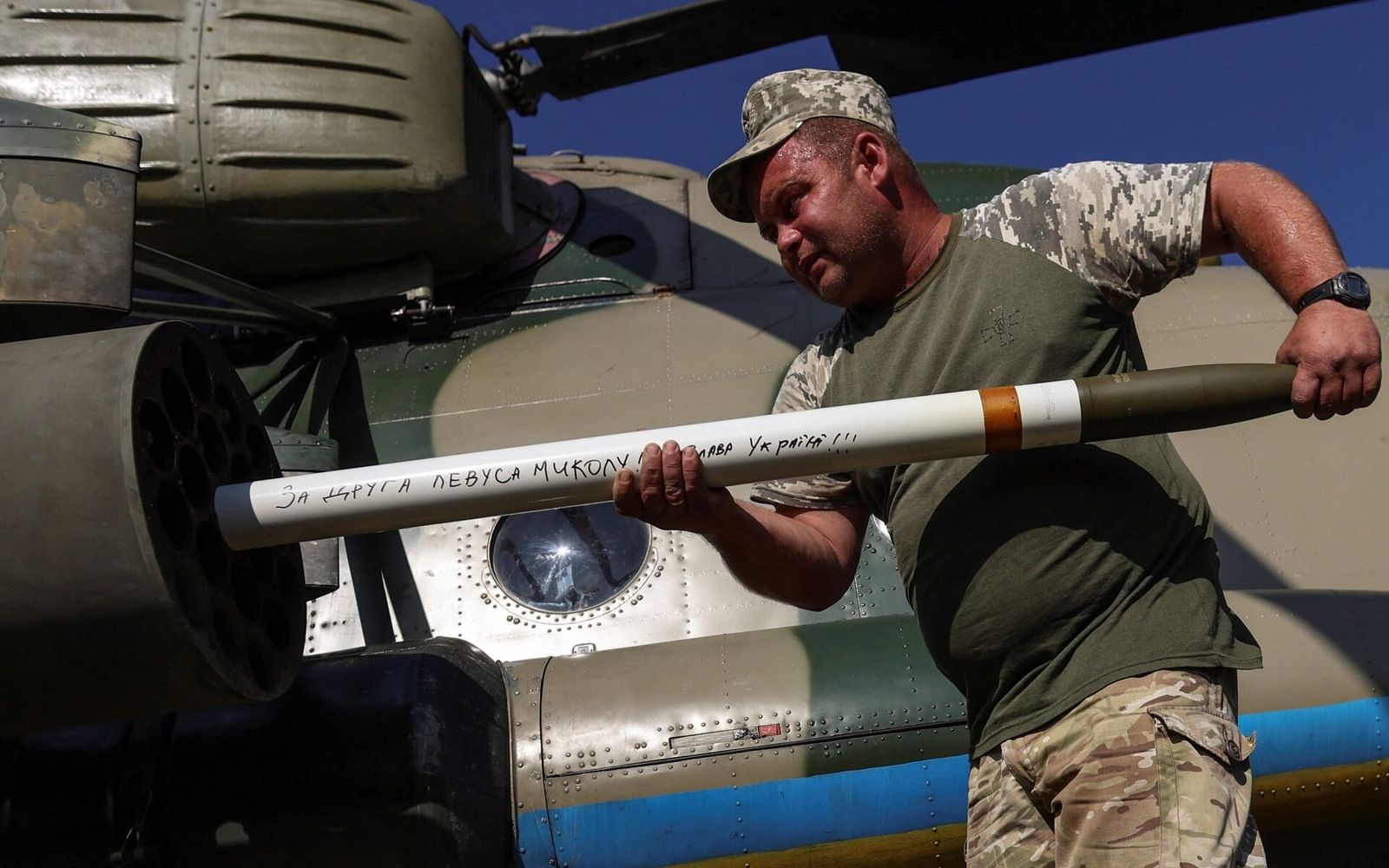 Украинский военнослужащий загружает неуправляемые ракеты в пусковую установку военного вертолета Ми-8 на фоне в неизвестном месте на востоке Украины. 30 сентября / Oleksandr Ratushniak / Reuters / The Telepraph