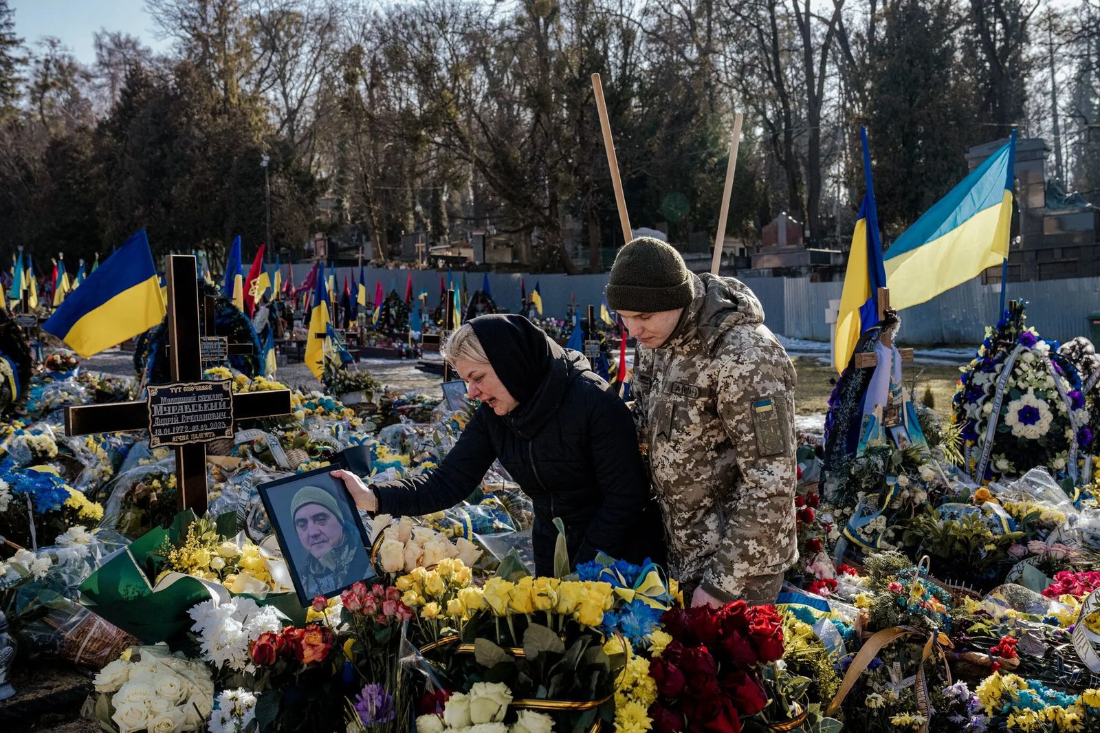 Сын утешает Викторию, оплакивающую потерю мужа Андрея на кладбище во Львове. Андрей служил в 125-й бригаде территориальной обороны, оборонявшей Бахмут. 16 февраля / Daniel Berehulak / The New York Times