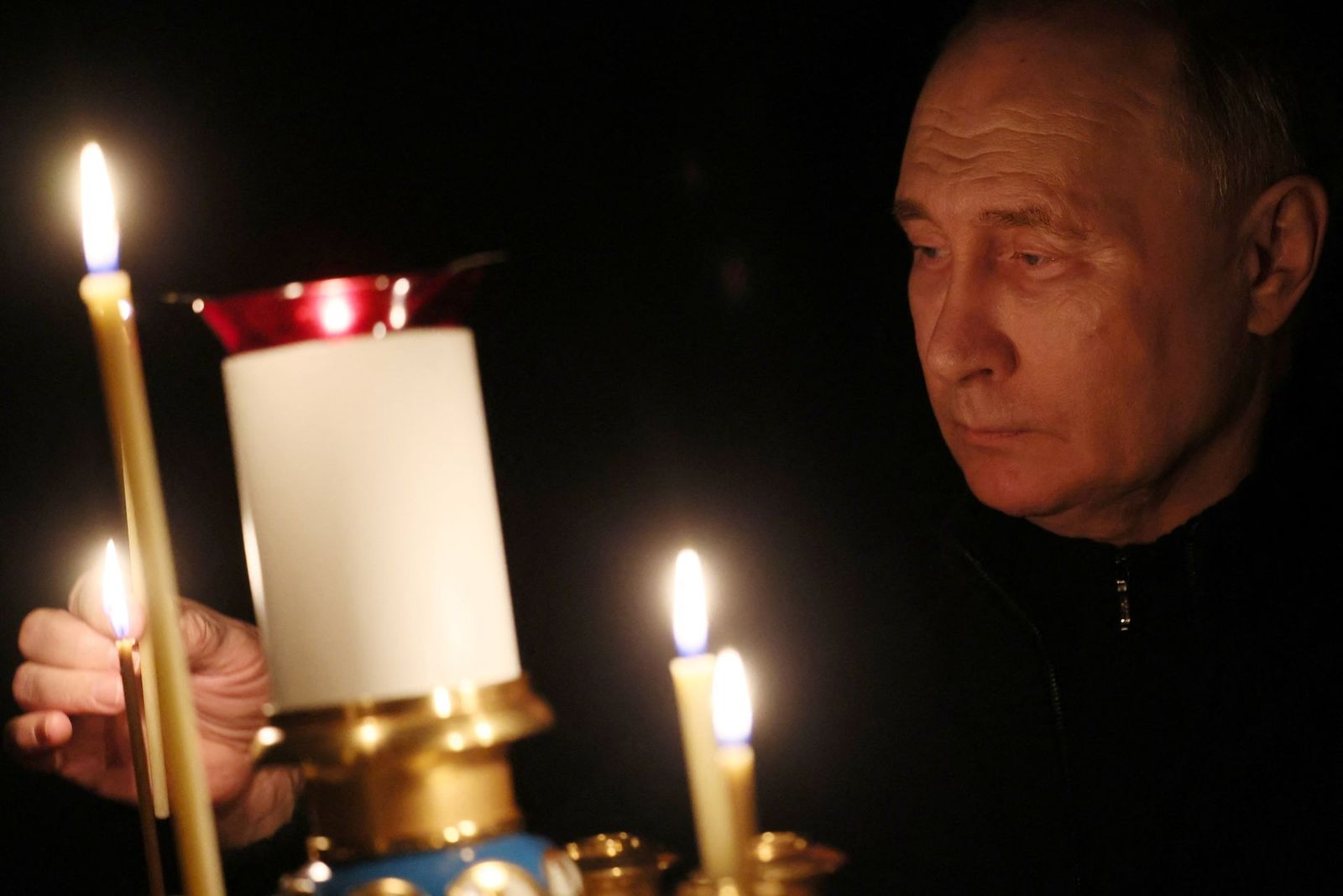 Владимир Путин зажигает свечу в память о жертвах теракта в «Крокус Сити Холле» в день национального траура в церкви в подмосковной резиденции Ново-Огарево. 24 марта / Mikhail Metzel / Sputnik / REUTERS