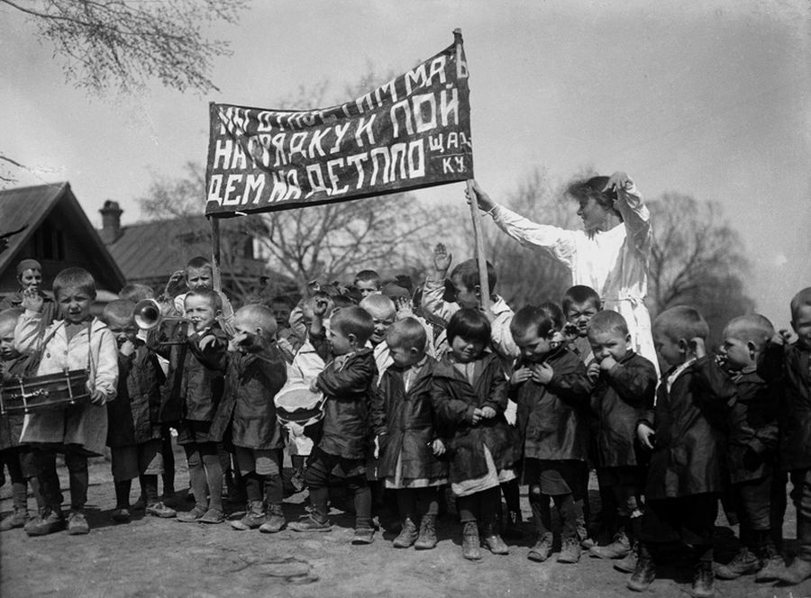 Первые деревенские детские сады, 1927 год. Надпись на плакате: «Мы отпустим мам на грядку и пойдем на детплощадку» / Аркадий Шайхет / МАММ